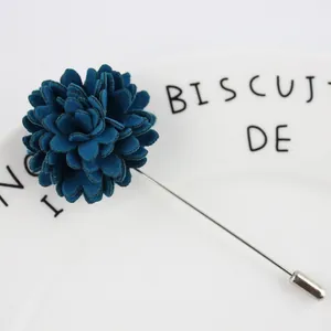 Détail macro d'une broche fleur en tissu bleu avec aiguille argentée sur plat