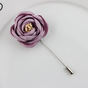 Detailed close-up of handmade purple fabric rose lapel pin with silver long metal needle