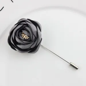 Detailed view of handmade grey fabric flower lapel pin with long silver metal needle