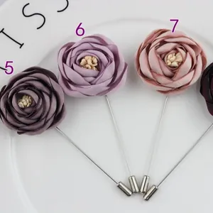 Handmade fabric rose lapel pins for men in purple and pink on a white plate