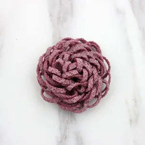 Macro shot of handmade dark pink metal woven flower accessory for DIY brooch or hairpin