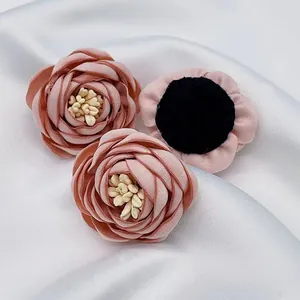 Vista macro di fiori di rosa in tessuto 3D fatti a mano con trama in raso su seta bianca