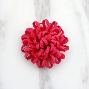 Detail of rose red fabric flower accessory with layered 3D petal texture for DIY crafts