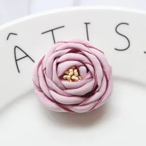 Dettaglio di una rosa in tessuto rosa fatta a mano con petali a strati e texture