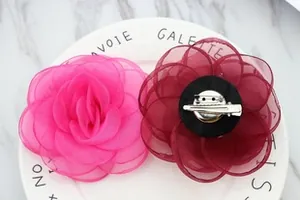 Detail of rose and wine red organza flower brooches with dual hair clip and pin backing