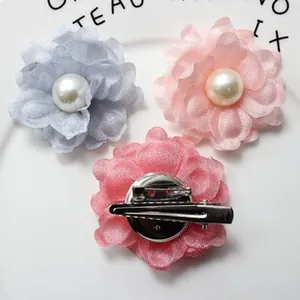 Detail of floral brooch hair clips with multilayer petals and central pearl decoration