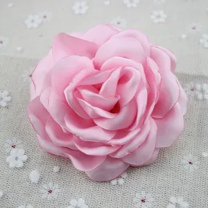 Detailed close-up of a pink handcrafted chiffon peony brooch with layered petals