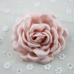 Close-up of soft peach pink chiffon peony brooch with layered satin fabric petals