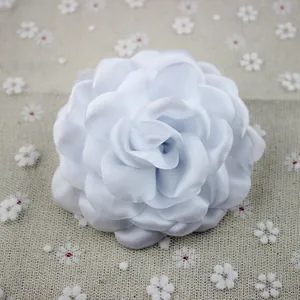 Detail of white multilayer chiffon peony flower brooch showing silk texture and petals