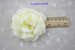 Detail view of cream chiffon flower brooch measuring 10cm on floral cotton fabric