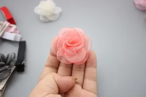 Detailopname van meerlagige koraalkleurige mesh rozenblaadjes voor DIY mode-accessoires