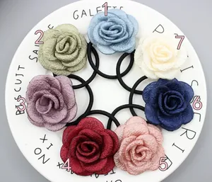 Detailansicht von 7-teiligem Set Satin-Rosen-Haargummis in verschiedenen Farben auf Teller