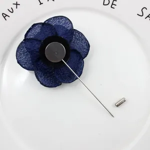 Detailed back view of dark blue fabric flower brooch with silver long pin fastener
