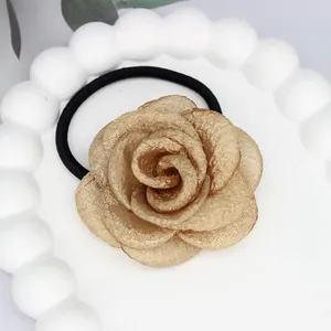 Eleganter champagnergoldener Kamelienblüten Haargummi für Damen mit schwarzem Elastikband