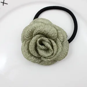 Detailansicht eines Rosen-Haargummis mit champagnerfarbener Stoffblüte und Falten