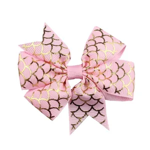 Close-up of pink grosgrain ribbon bow with golden fish scale pattern for hair accessories