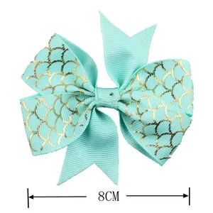 Detail showing 8cm mint green ribbed bow accessory with golden mermaid scale pattern