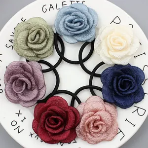 Set aus 7 farbigen Stoff-Haargummis mit Blumenmuster in einer weißen Keramikschale