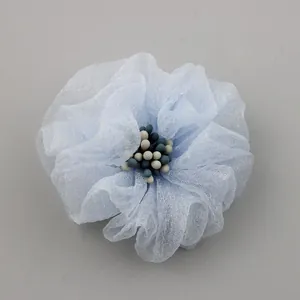 Vue macro d'une fleur en gaze bleu clair de 5cm avec un cœur de perles bicolores