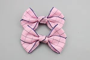 Pink plaid bow accessories with dark blue grid lines and ribbed fabric texture for DIY