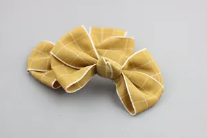 Yellow plaid double bow hair clip for girls with ribbed fabric texture on gray background