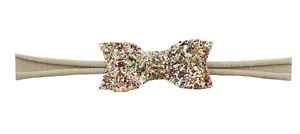 Détail d'un bandeau en nylon kaki avec un nœud à paillettes colorées pour nouveau-né