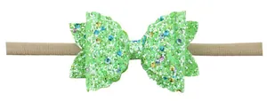 Detail van groene glitter strik hoofdband met golvende randen en gekleurde lovertjes