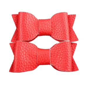 Close-up of red faux leather bow hair clips with detailed litchi texture for girls