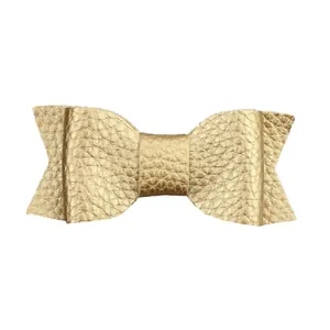 Macro detail of golden faux leather bow hair clip with textured litchi pattern