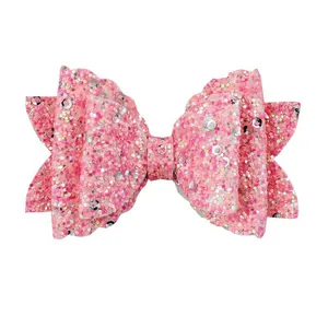 Detail of pink glitter bow hair clip with layered sequins and shimmering surface finish