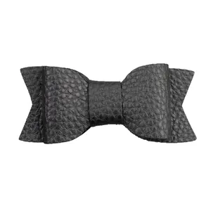 Close-up of matte black PU leather bow hair clip with detailed lychee grain texture