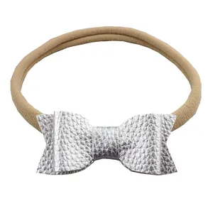 Silver leather swallowtail bow on soft nude nylon headband for newborns and toddlers