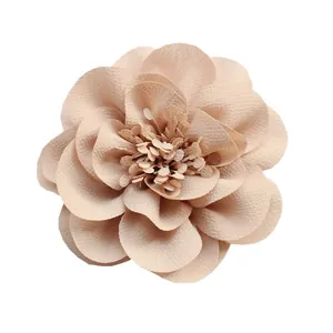 Macro di un accessorio floreale in chiffon beige con petali a strati e stami dettagliati