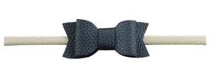 Detailed close-up of black faux leather bow headband with a high-elastic nylon band