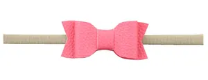 Detail of pink faux leather bow on soft nylon headband for newborn babies