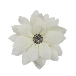 Detail of white chiffon lotus flower fabric accessory with sparkling rhinestone center