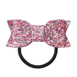Détail macro du chouchou nœud rose pailleté avec élastique noir à haute élasticité