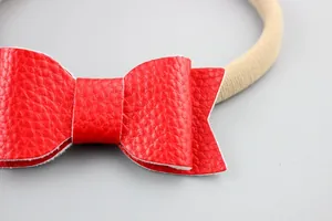 Soft nylon baby headband featuring a vibrant red faux leather bow with litchi texture