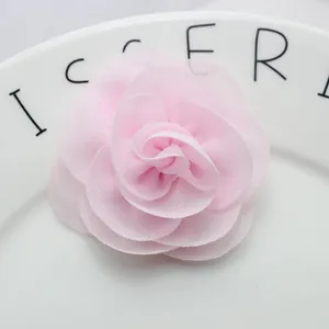 Macro shot of 6cm pink chiffon fabric camellia flower with layered pearl petals for DIY crafts