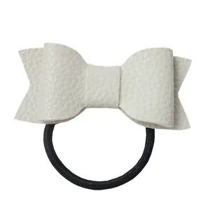 Close-up of off-white faux leather hair tie with lychee texture and black elastic band