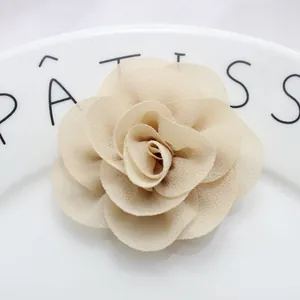 Macro detail of multilayer beige chiffon flower with central pearl for DIY fashion accessories