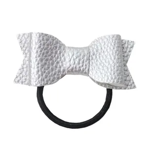Detail view of silver faux leather bow hair tie with textured lychee pattern finish