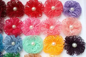 Macro detail of handmade fabric flower petals with pearl center in vibrant assorted colors