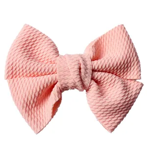 Detail view of the pink waffle fabric texture and soft knot on the girls hair bow clip