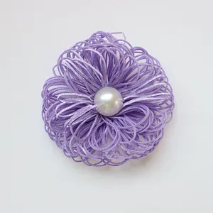 Detail of lavender woven ribbon flower with a central glossy white pearl accent