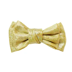 Detailed close-up of a 10cm gold sequin bow clip with a sparkling glitter texture