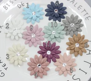 Fiori di margherita fai da te in microfibra con strass in undici colori su un piatto