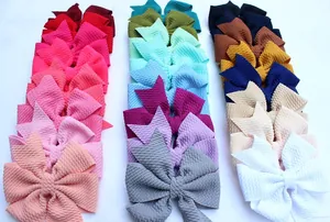 Fasce con fiocco a nido d'ape per bambina in colori assortiti su sfondo bianco puro