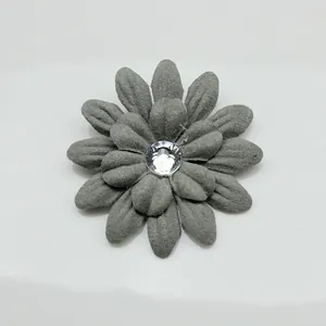 Dettaglio di un fiore in tessuto grigio con centro in cristallo per decorazioni DIY