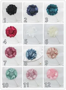 Detail showing twelve colors of handmade fabric flower brooches with pearl pin caps